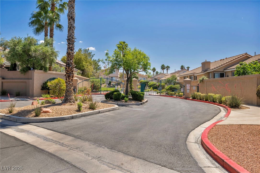 2180 Polynesia Circle Henderson, NV 89074 - Photo 38 of 53 View of asphalt road featuring curbs, a gate, a re
