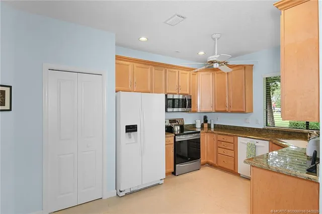 a kitchen with granite countertop a sink window and cabinets