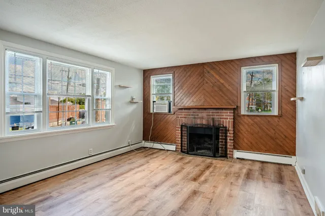 an empty room with windows and fireplace