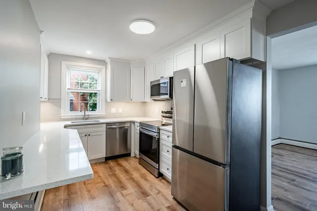 a kitchen with stainless steel appliances granite countertop a refrigerator and a stove top oven