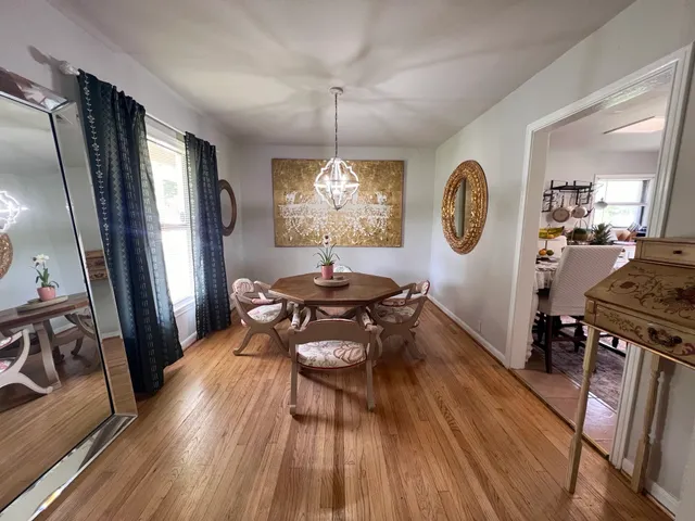 a view of a hallway with wooden floor and a living room
