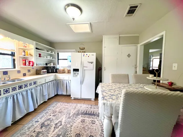 a living room with furniture a large window and stainless steel appliances