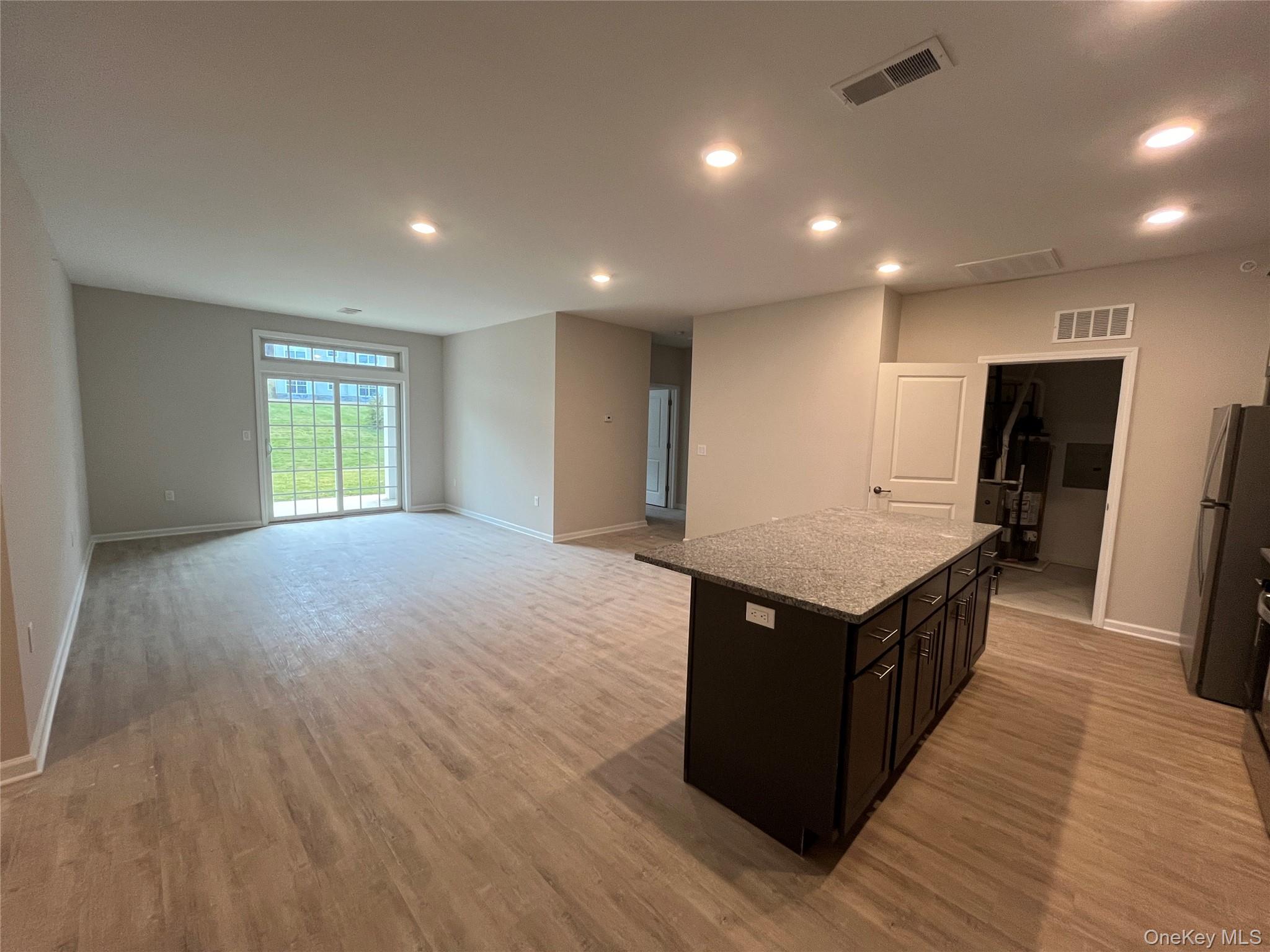 415 Tower Ridge Circle Middletown, NY 10941 - Photo 2 of 5 a kitchen with stainless steel appliances granite countertop a sink wooden floor and a refrigerator