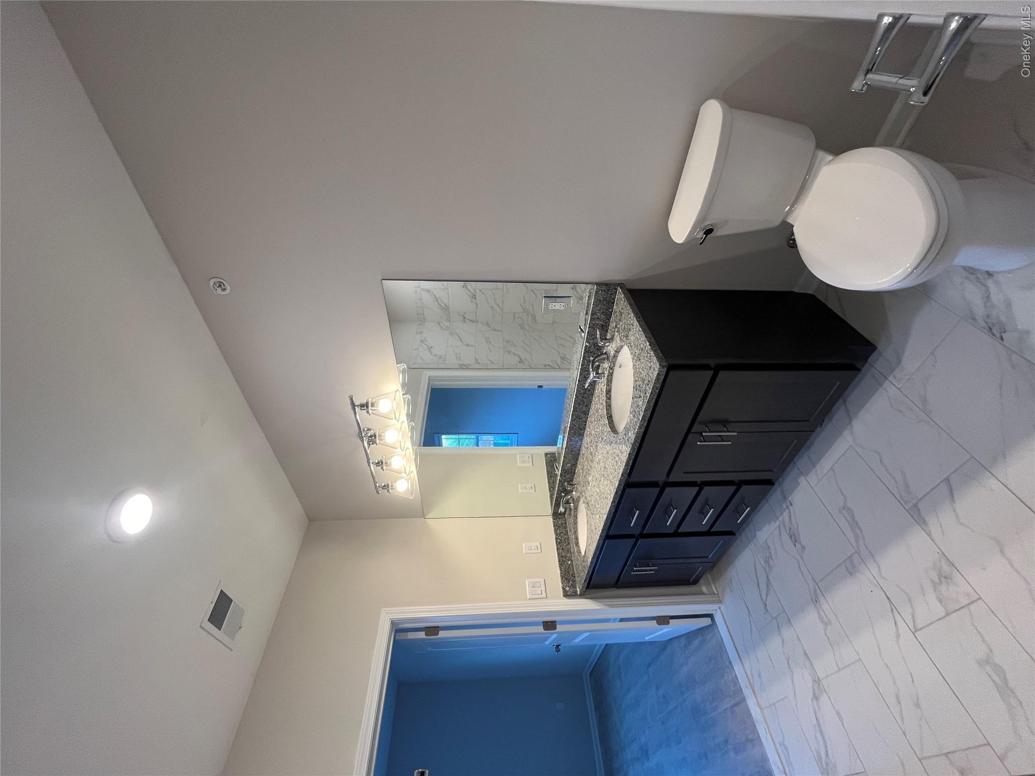 415 Tower Ridge Circle Middletown, NY 10941 - Photo 4 of 5 a bathroom with a granite countertop toilet sink and mirror