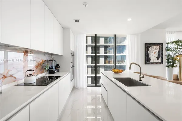 a large kitchen with a sink and cabinets
