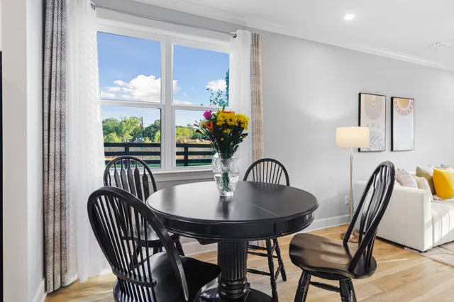 a dining room with furniture potted plants and wooden floor
