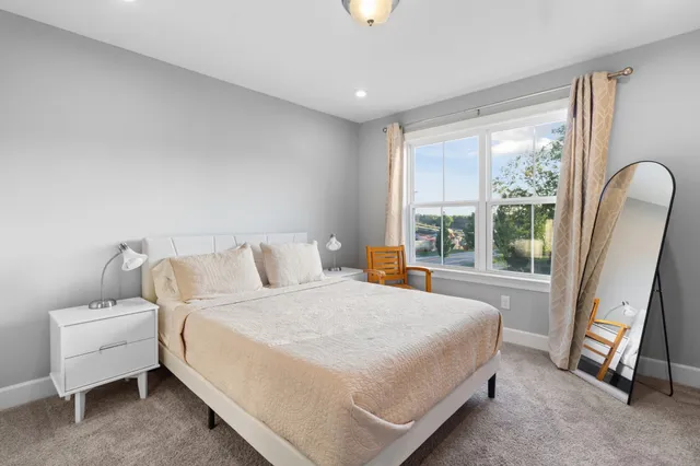 a bedroom with a bed and painting on the wall