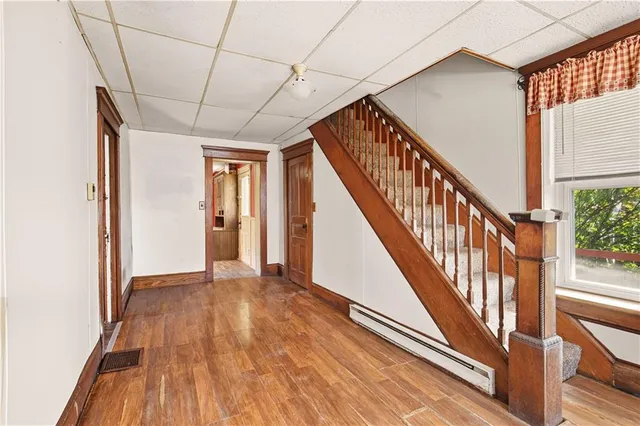 a view of a hallway with wooden floor and staircase