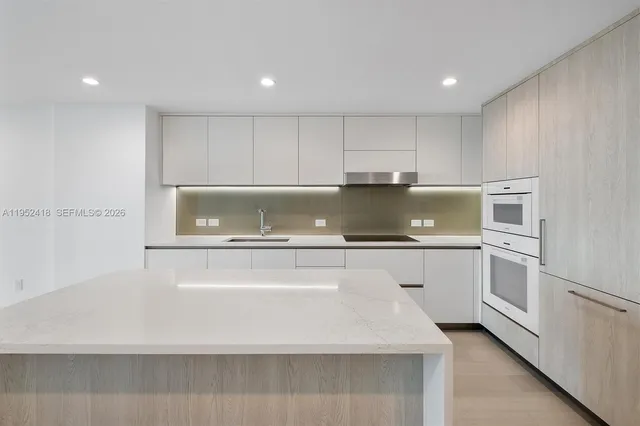a kitchen with granite countertop white cabinets and white appliances
