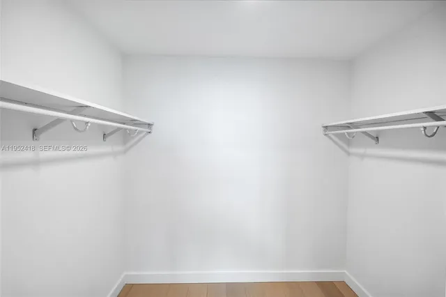 a view of an empty room with wooden floor and glass door