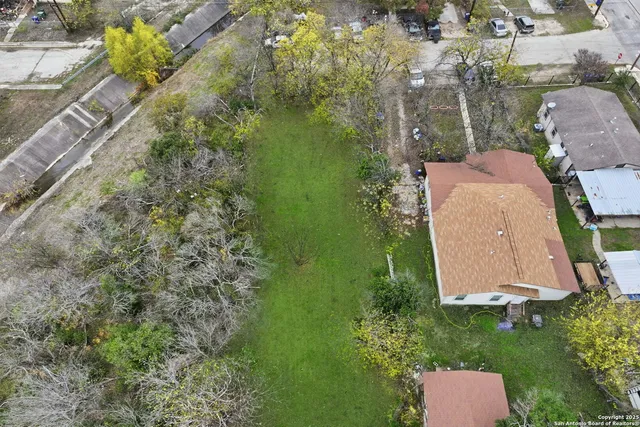 an aerial view of a house with a yard and lake view
