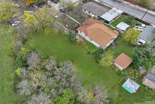 an aerial view of residential house with outdoor space and trees all around