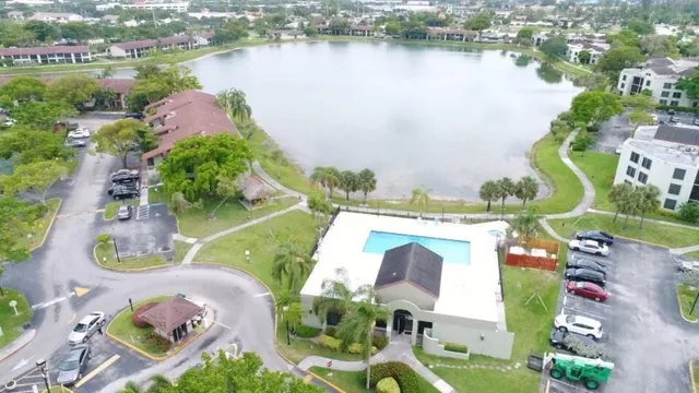 an aerial view of residential houses with outdoor space and lake view