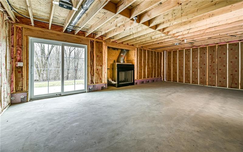 309 Parkhill Road Baden, PA 15005 - Photo 22 of 25 This lower level room has fered and insulated walls with wood burning fireplace, sliding glass door that walks out to scenic back yard, plumbed for full bathroom and is ready for your personal finishes.