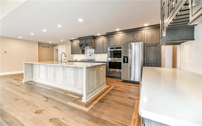 309 Parkhill Road Baden, PA 15005 - Photo 6 of 25 An abundance of cabinetry with double ovens, side by side refrigerator with water and ice dispenser. Mini bar area with wine refrigerator and wine racks under cabinetry.