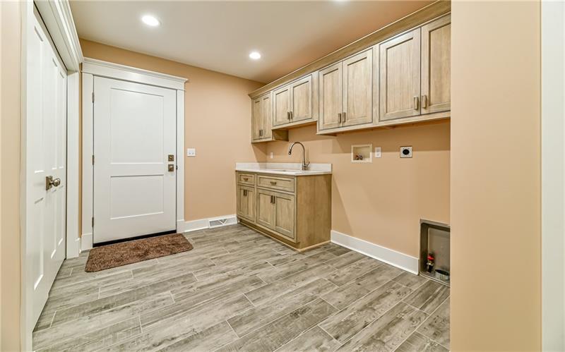 309 Parkhill Road Baden, PA 15005 - Photo 9 of 25 Main level laundry/mud room is set up for either gas or electric dryer. Easy to maintain ceramic flooring, double door coat closet, utility sink and plenty of cabinetry.