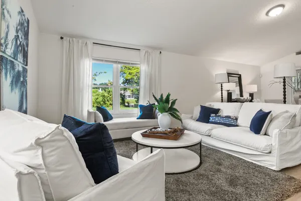 a living room with furniture a fireplace and a large window