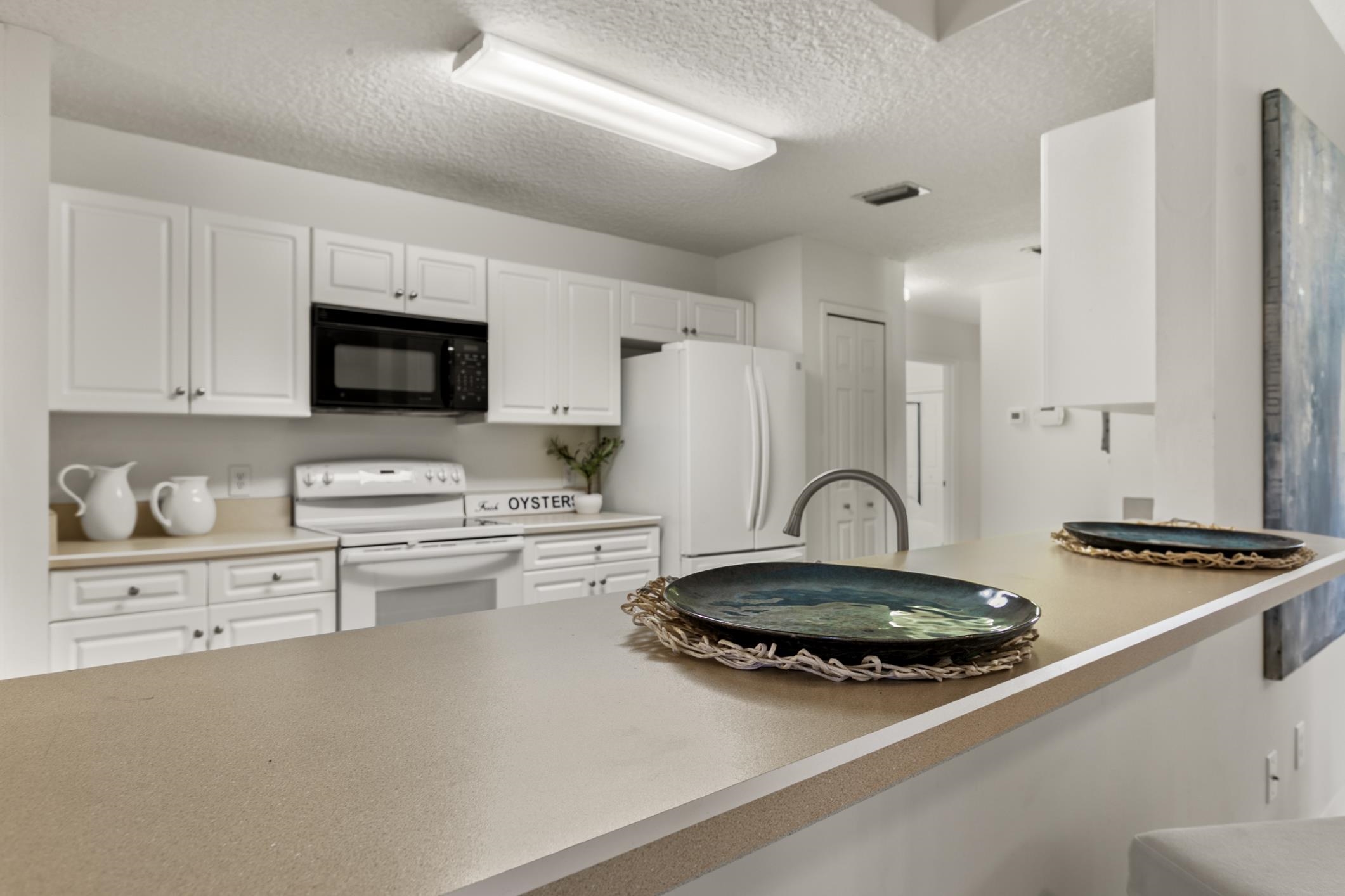 541 Peninsula Court St. Augustine, FL 32080 - Photo 27 of 63 a kitchen with granite countertop a stove a sink dishwasher and a refrigerator with wooden floor