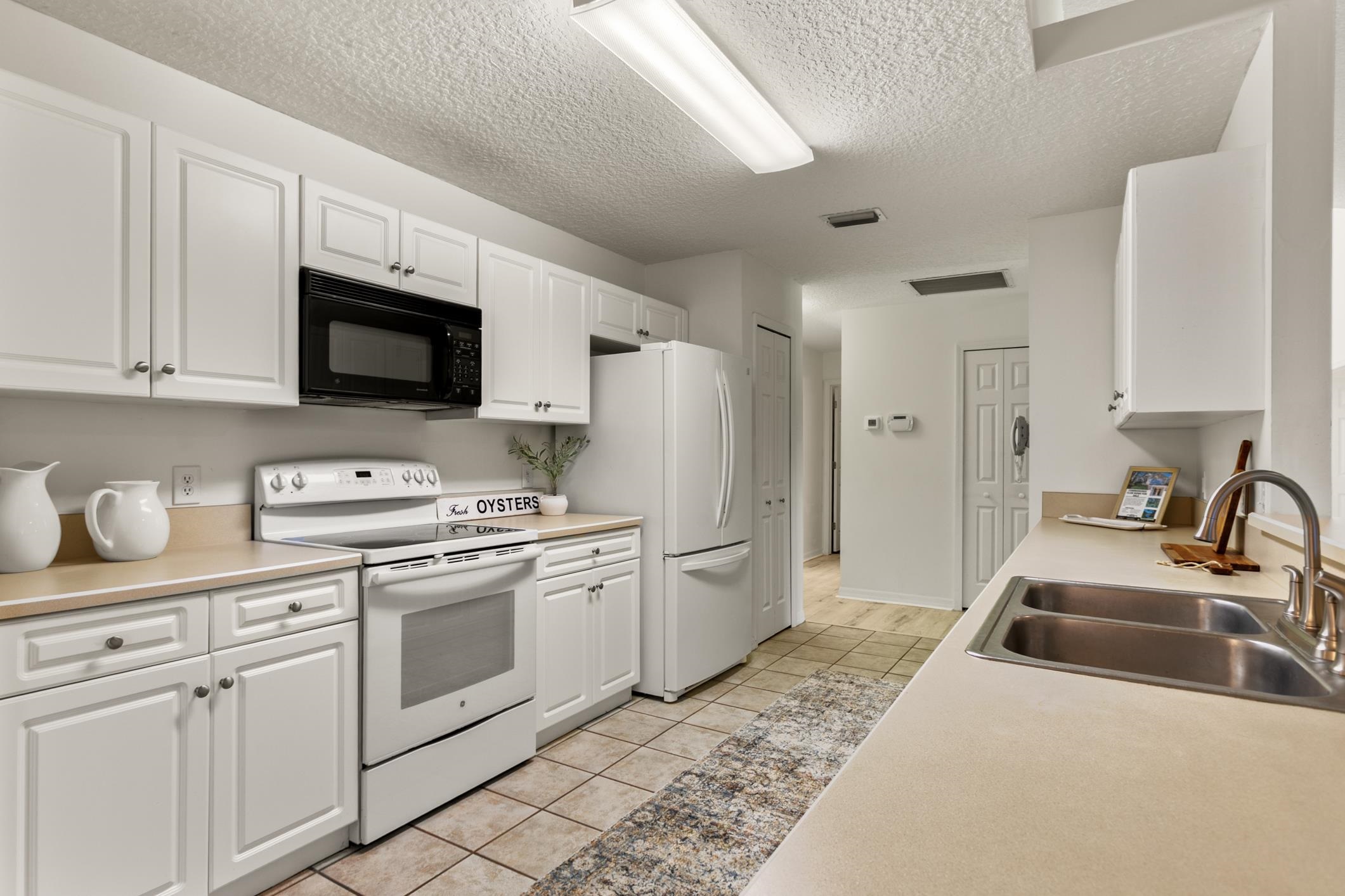 541 Peninsula Court St. Augustine, FL 32080 - Photo 28 of 63 a kitchen with white cabinets sink and stainless steel appliances