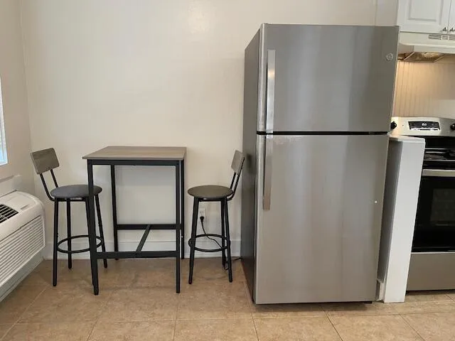 a view of a livingroom with furniture and a refrigerator