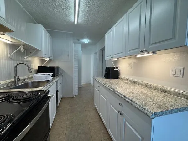 a kitchen with stainless steel appliances granite countertop a sink stove and cabinets
