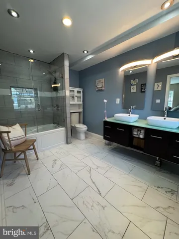 a living room with stainless steel appliances kitchen island granite countertop furniture a rug and a glass door