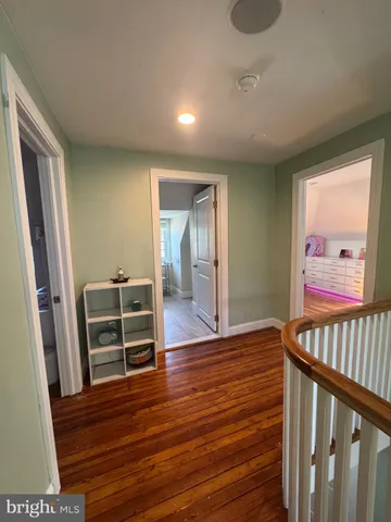 a view of a hallway with wooden floor and furniture