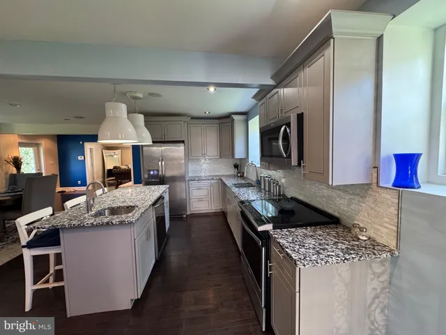 a kitchen with granite countertop counter top space a sink stainless steel appliances and cabinets