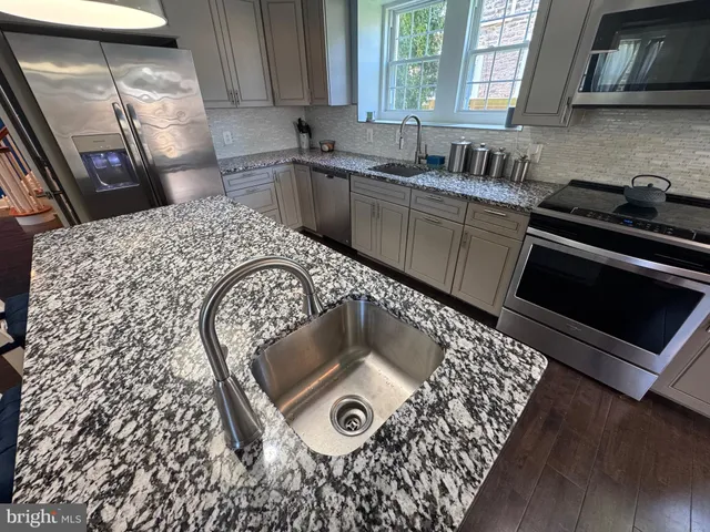 a kitchen with a sink a stove and cabinets