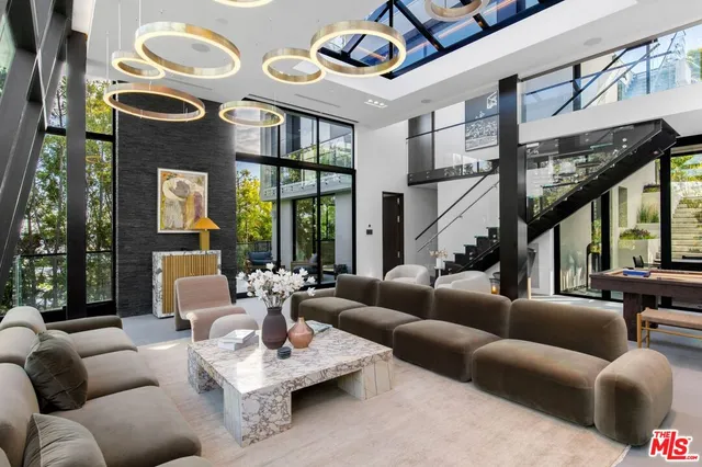 a living room with furniture a fireplace and large windows