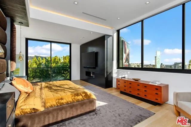 a bedroom with a bed and a large window