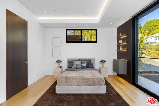 a bedroom with a bed and a large window