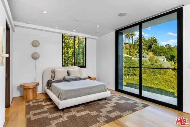 a bedroom with a large window and a bed
