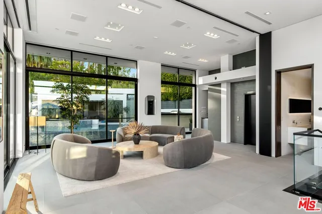 a living room with furniture and large windows