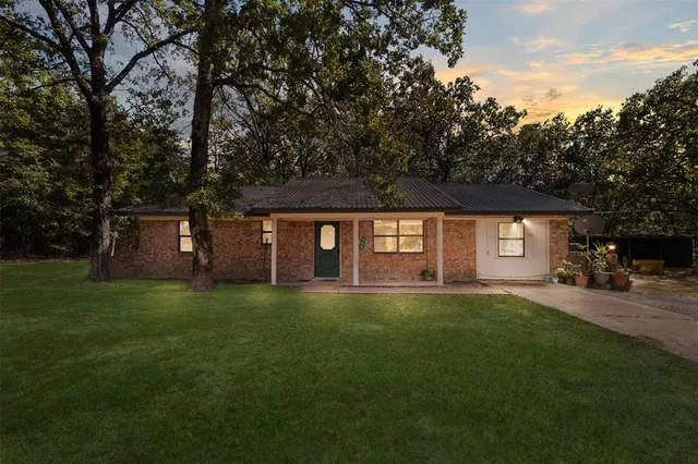 a view of a yard in front of a house with large tree