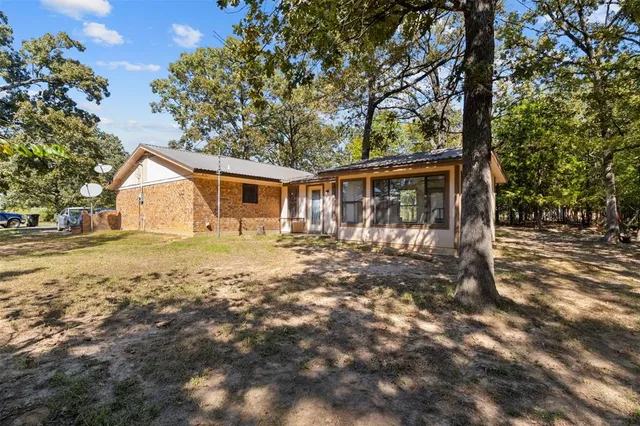 a view of house with backyard and tree