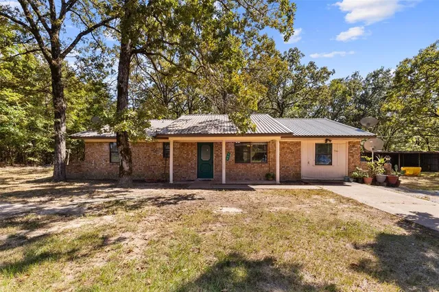 a front view of a house with a yard and trees