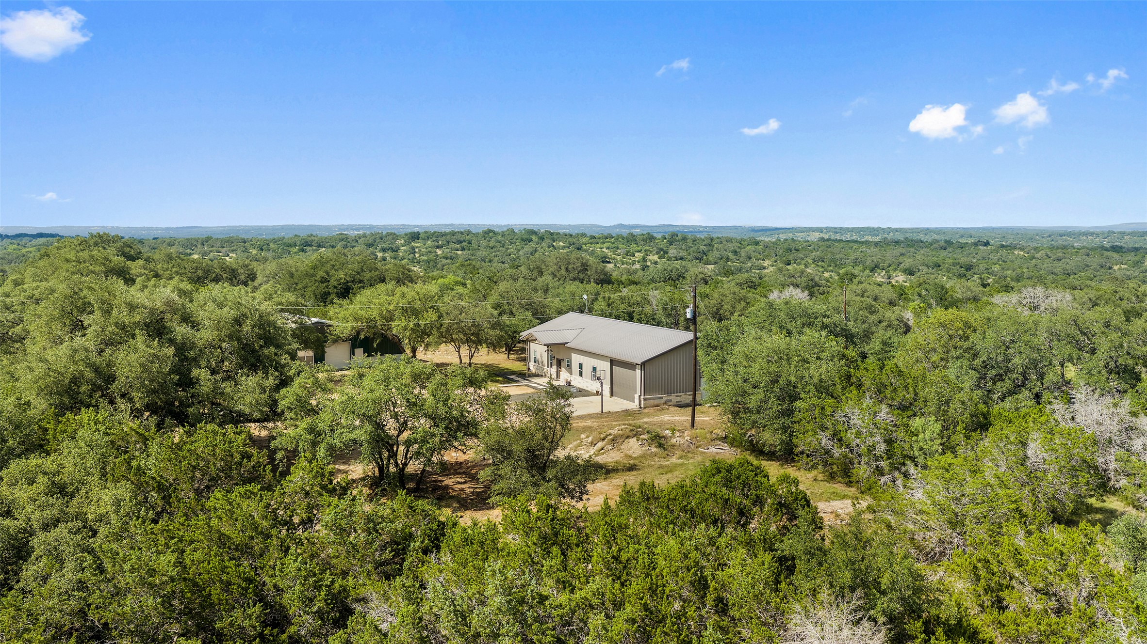 764 Stubbs Road Johnson City, TX 78636 - Photo 26 of 29 Perched amidst a verdant landscape, this modern abode offers secluded living with vast natural surroundings.