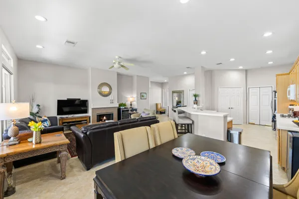a living room with furniture kitchen view and a flat screen tv