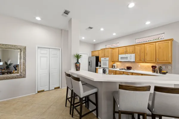 a kitchen with a dining table chairs refrigerator and sink