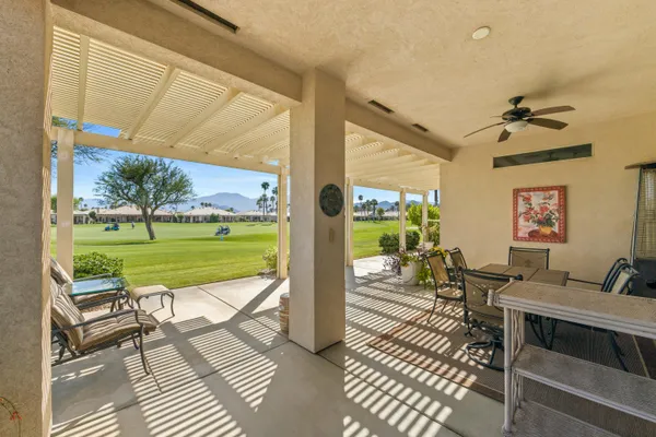 a view of a patio with table and chairs potted plants with wooden floor and fence