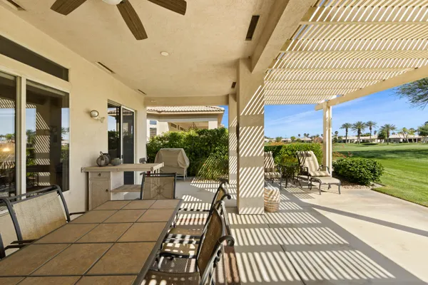 a view of a patio with dining table and chairs