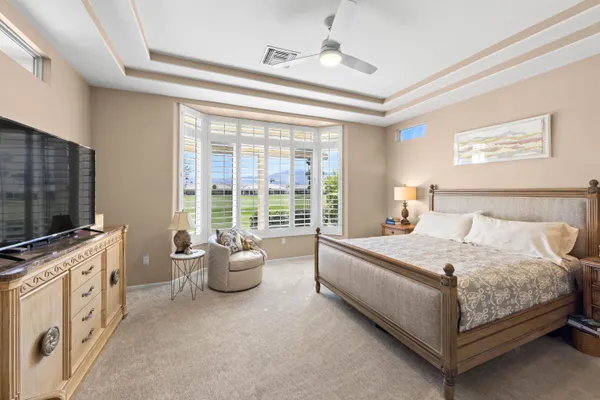 a spacious bedroom with a bed and a flat screen tv