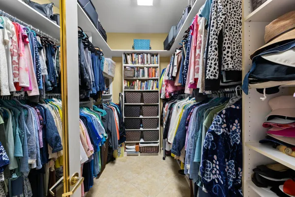 a view of walk in closet with clothes and shoes