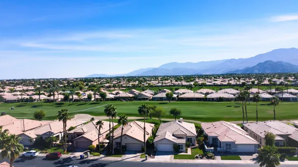 a view of a table and chairs under an umbrella in a garden