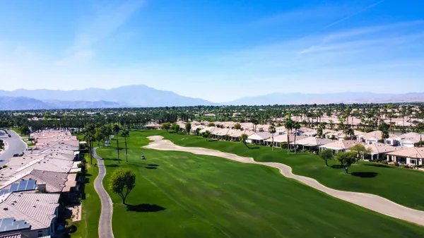 an aerial view of a city with lots of residential buildings and mountain view in back