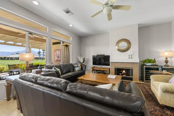 a living room with furniture a fireplace and a large window