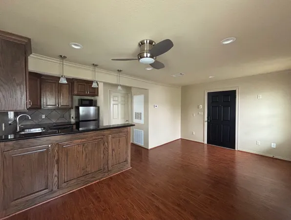 a kitchen with granite countertop a stove sink and cabinets