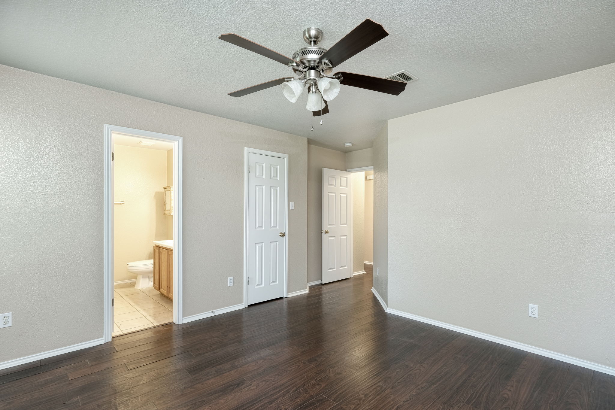 124 Hunter Rex Way Kyle, TX 78640 - Photo 7 of 14 Spacious room featuring dark wood-finish flooring, light neutral walls, and a ceiling fan with integrated lighting