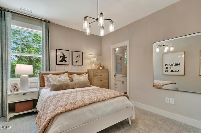 a bedroom with a large bed and a chandelier
